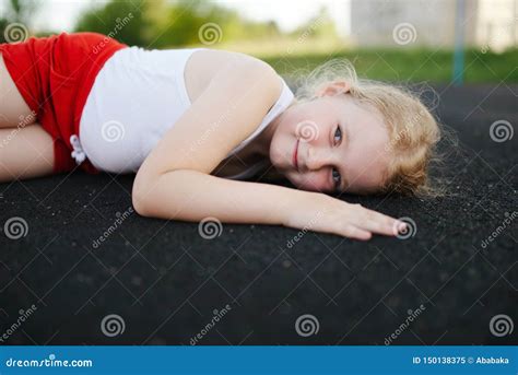 Little Girl Lying On Floor Outdoors Stock Image Image Of Little Road