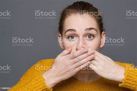 Stunned Young Woman Covering Her Mouth For Mistake Or Regret Stock