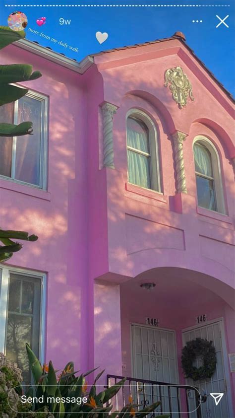 A Pink House With White Trim And Windows