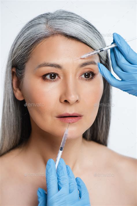 Attractive Naked Asian Woman And Doctors In Latex Gloves Holding