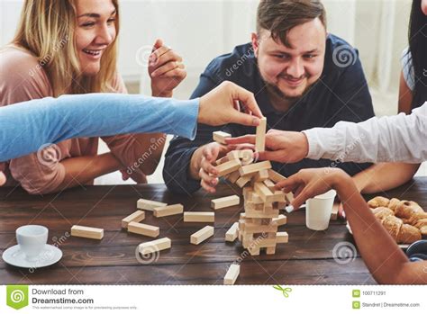 You have to try some of the card games listed below. Group Of Creative Friends Sitting At Wooden Table. People Having Fun While Playing Board Game ...