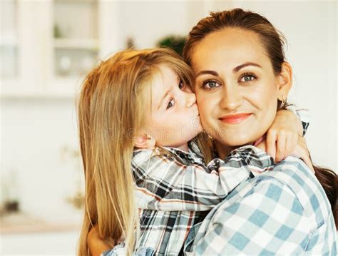 A Beautiful Young Mother And Her Four Year Old Daughter Are Hugging In The Kitchen Stock Image