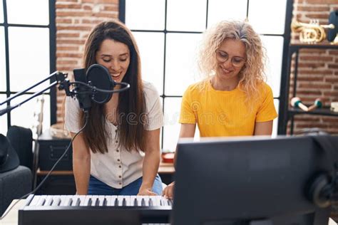 Two Women Musicians Singing Song Playing Piano Keyboard At Music Studio