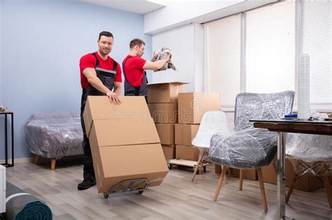 Movers Packing The Products In The Living Room Stock Photo Image Of