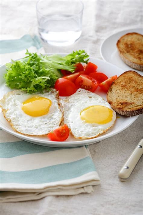 Breakfast Fried Eggs Bread Tomato And Lettuce On A Plate Stock