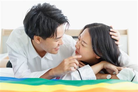 Lgbtq Couple Lovers A Handsome Girl As A Man Or Femme Girl Laying On A Bed With The Rainbow