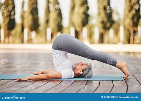 Mujer Madura En Ropa Deportiva Practicando Halasana De Yoga Al Aire