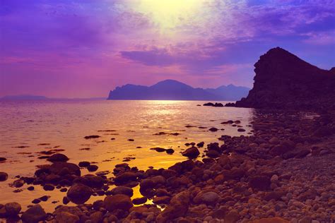Purple Sunset Over Rocky Beach High Quality Image