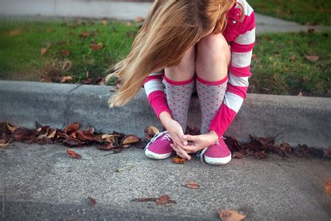Young Girl Sitting On Sidewalk Hugging Her Knees By Stocksy Contributor Dina Marie