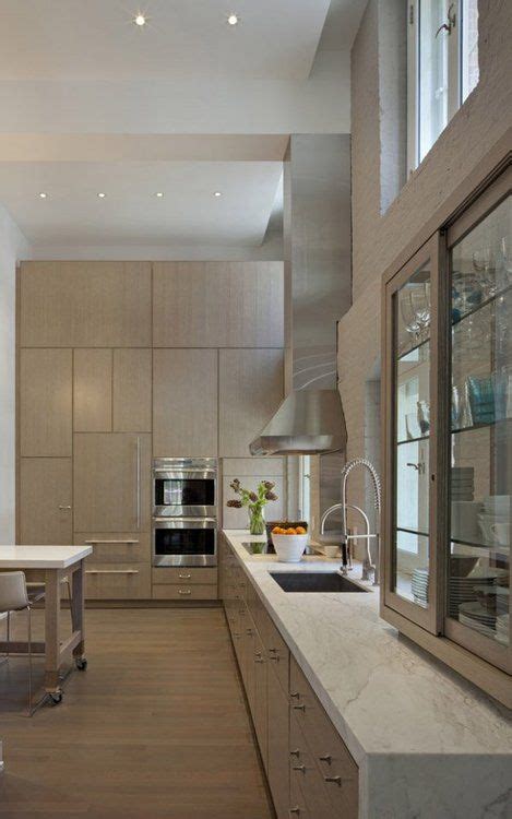 Extend cabinets to ceiling with glass cabinets kitchen design. Modern kitchen: high ceilings; monochrome; waterfall ...