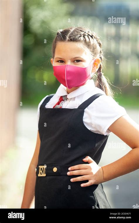 Una Niña De Diez Años En Un Uniforme Escolar Con Su Pelo En Trenzas Y Usando Una Máscara De