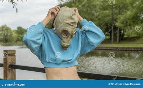 The Girl Puts On A Gas Mask On The River Bank Alienation In The City