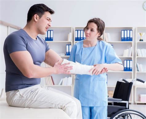 Doctor And Patient During Check Up For Injury In Hospital Stock Image