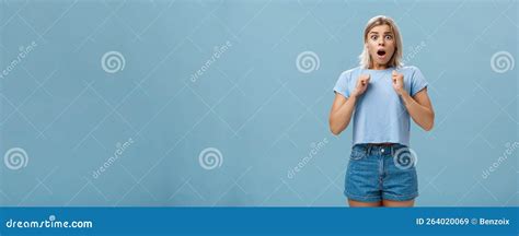 Studio Shot Of Stunned Shocked Girl Standing In Stupor With Dropped Jaw