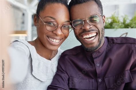 Positive Dark Skinned Smiling Woman And Man Have Fun Together Make