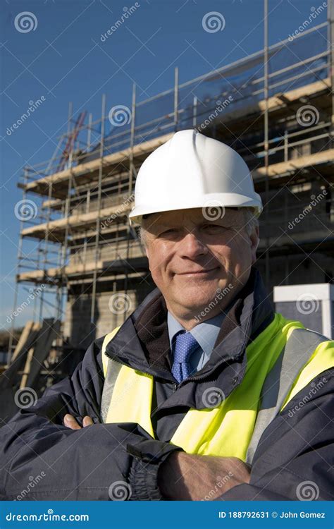 Smiling Property Developer Building In Front Of Construction Site
