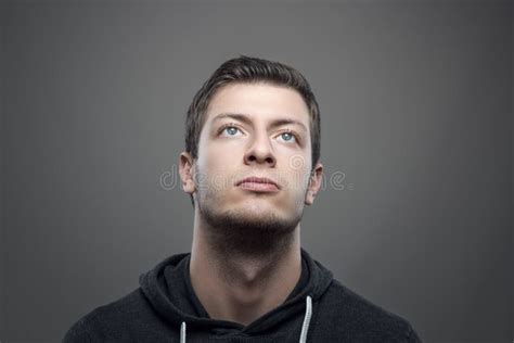 Moody Portrait Of Young Casual Man Looking Up With Illuminated Face