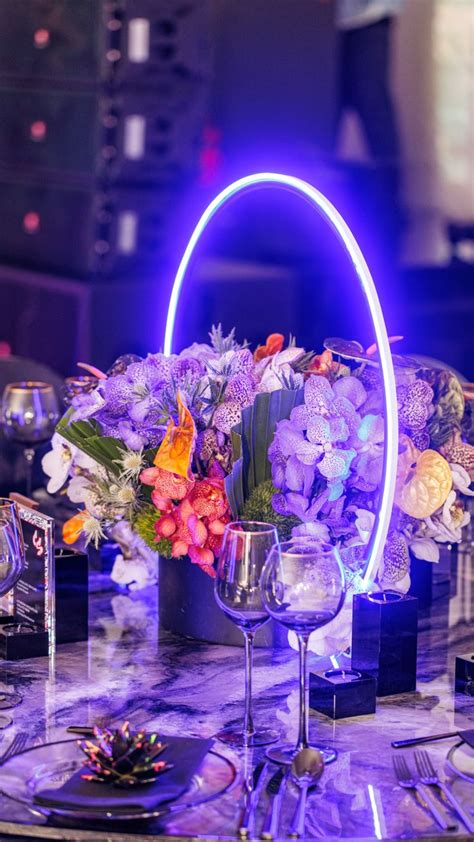 A Creative And Unique Table Centerpiece With Bright Floral And Neon Light