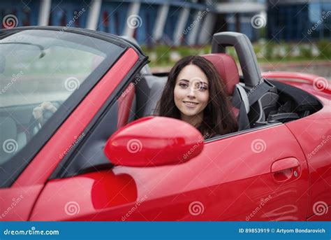 Pretty Young Brunette Woman Driving Luxury Red Cabriolet Car Stock