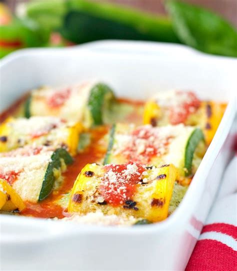 A Casserole Dish With Zucchini And Peppers In It On A Red And White Towel
