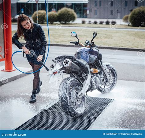 An Attractive Girl Washing Her Motorcycle In Service Stock Image