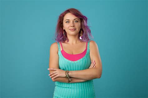 Studio Portrait Of A 30 Year Old Woman With Purple Hair On A Blue