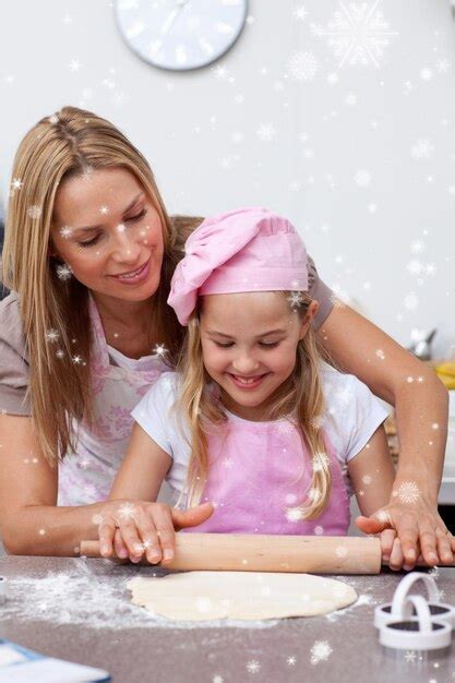 Madre E Hija Horneando Galletas En La Cocina Con Nieve Cayendo Foto