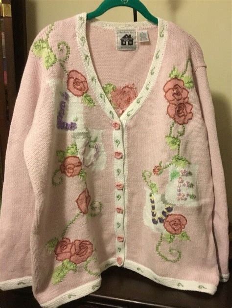 this beautiful sweater has lovely light pink and pink roses 🌹 in rows along with a decorative