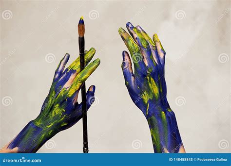 Graceful Hands Of The Artist With A Brush Hands In Blue And Yellow