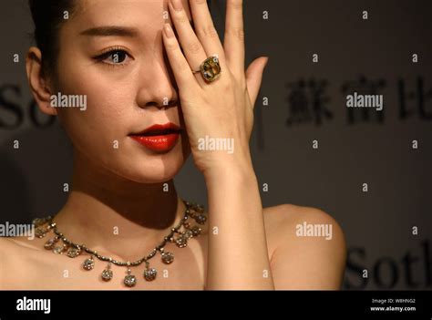 A Model Shows A Yellow Diamond Ring And A Diamond Necklace During A
