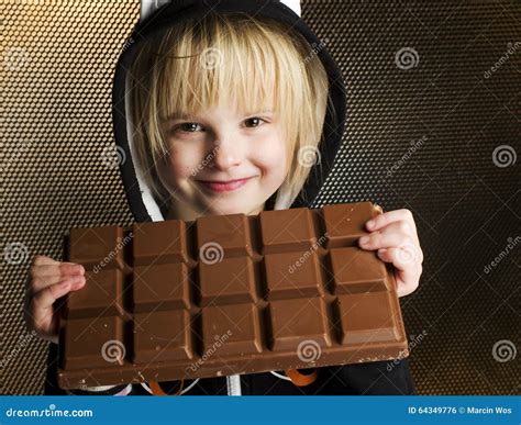 Young Female Child Holding With Both Hands Big Chocolate Bar In Stock
