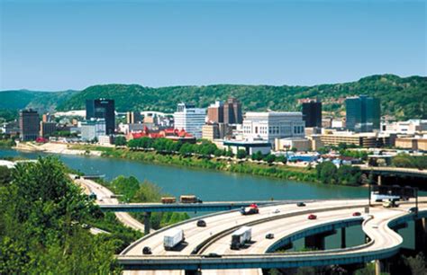 An Aerial View Of A Highway With Cars Driving On It And The City In The