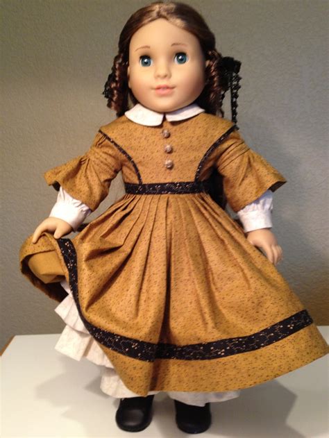 The Doll Is Wearing A Brown Dress And Black Shoes