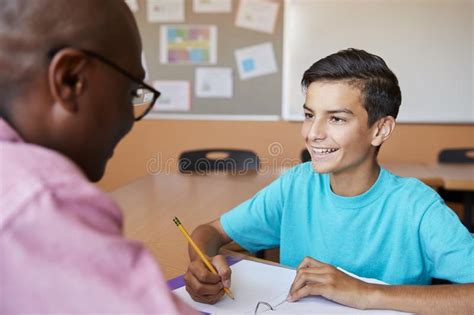 High School Tutor Giving Male Student One To One Tuition At Desk Stock