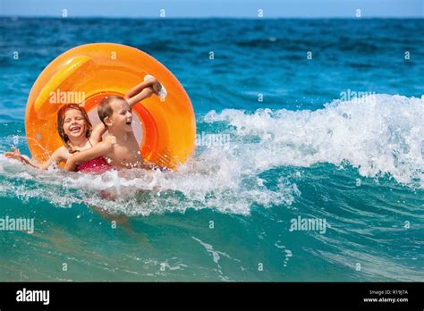 Happy Kids Have Fun In Sea Surf On Beach Joyful Couple Of Children On