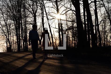 Couple Walking Holding Hands Down A Dirt Road — Photo — Lightstock