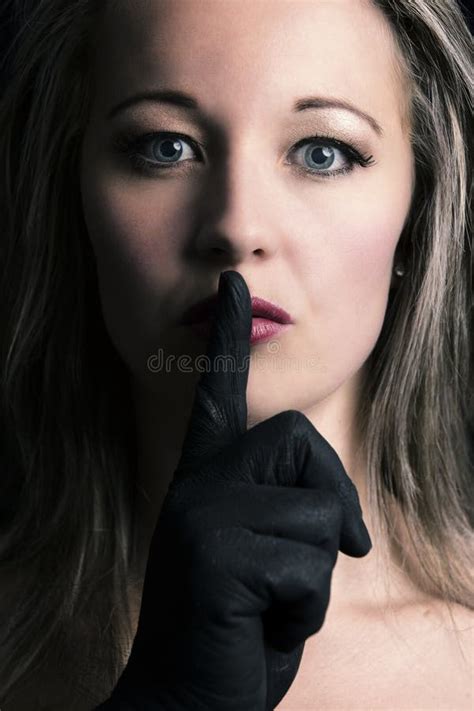 Frightened Blonde Woman Silenced With Finger In Black On Her Face