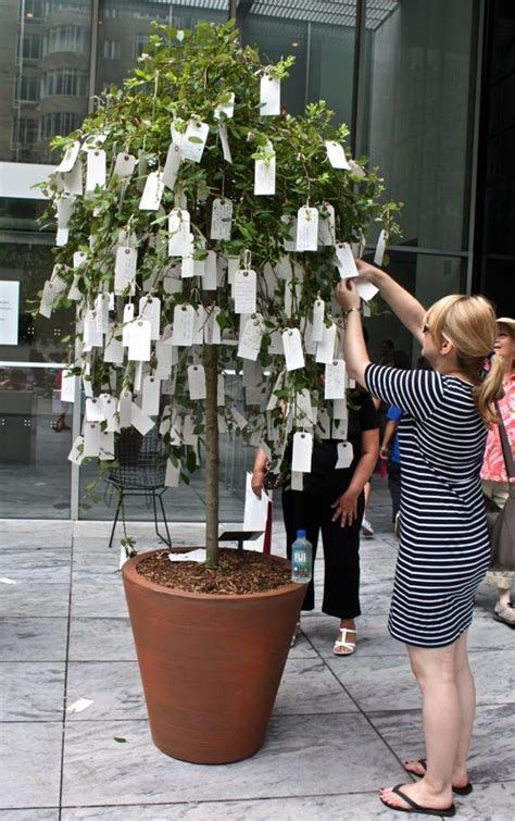 A Woman Is Placing Notes On A Tree