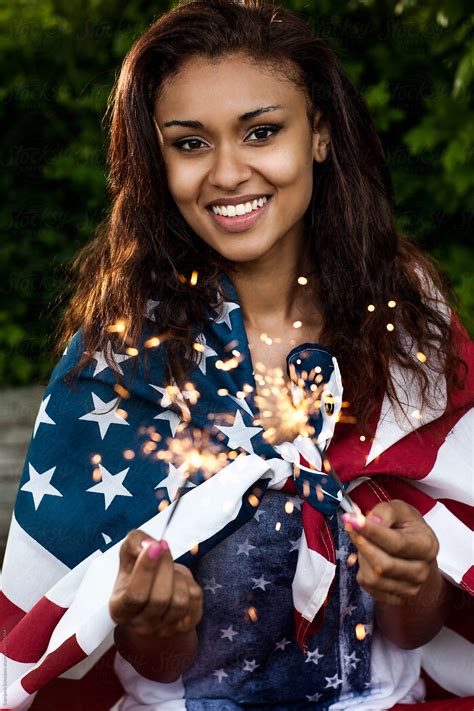 Beautiful Young African American Woman Holding An American Flag By