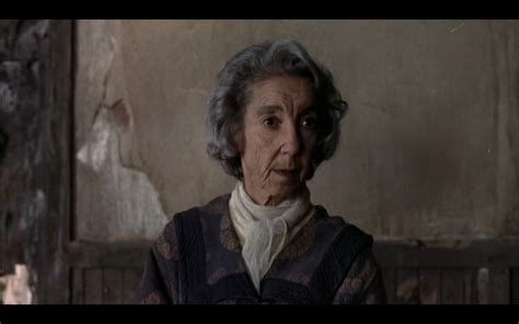 An Old Woman With Grey Hair Wearing A Sweater