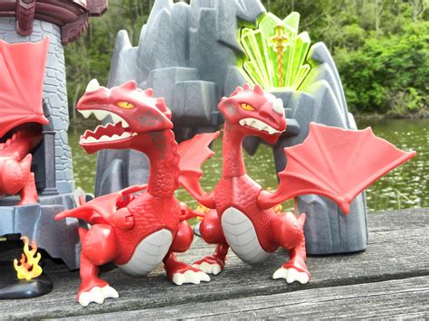 Two Red Dragon Figurines Sitting Next To Each Other On A Wooden Table