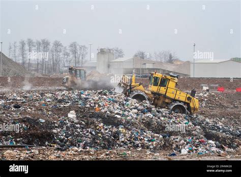 Dump Municipal Waste Workers With Trucks And Bulldozers At Work In