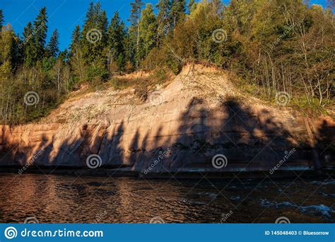Beautiful Golden Sunrise Over Forest River With Sandstone Cliffs On The
