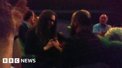 a woman is surprised after seeing her partner propose to her on the big screen bbc news