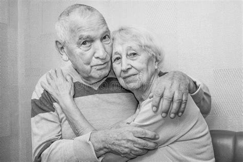 Happy Affectionate Mature Old Man And Woman Embracing Looking At Camera