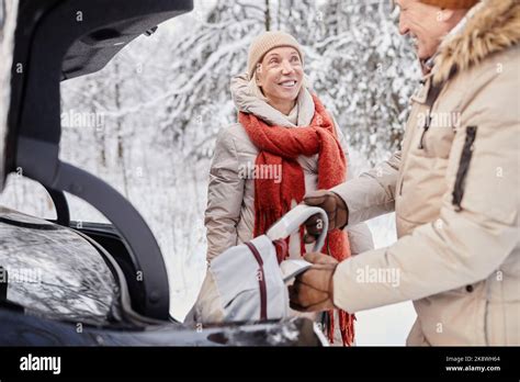 Portrait Of Mature Couple Enjoying Winter Getaway In Nature Standing By