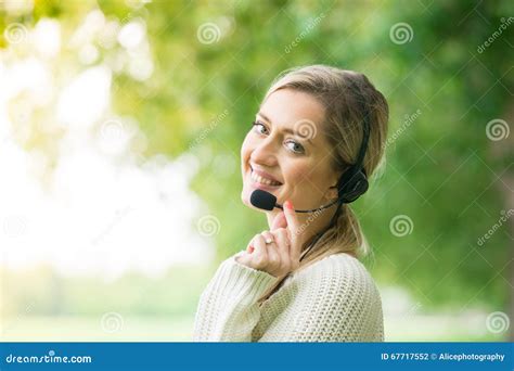 Business Woman Talking Using Her Headset In The Park Stock Photo