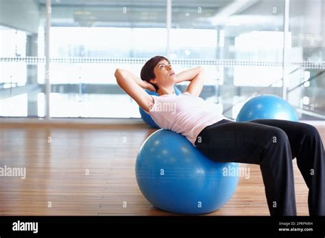 Sit Ups Woman Doing Sit Ups Using Pilates Ball In A Gymnasium Stock
