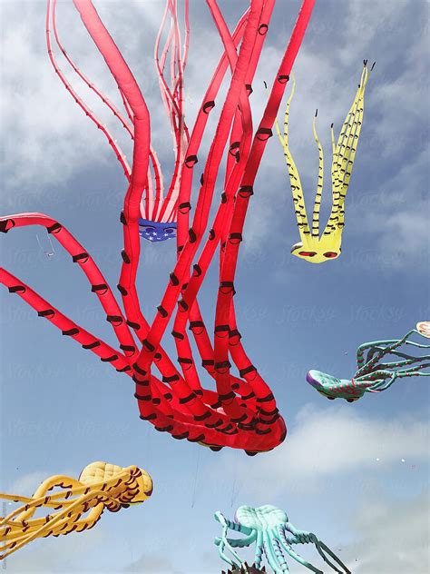 Octopus Shaped Kites Flying In The Blue Sky With Clouds By Stocksy