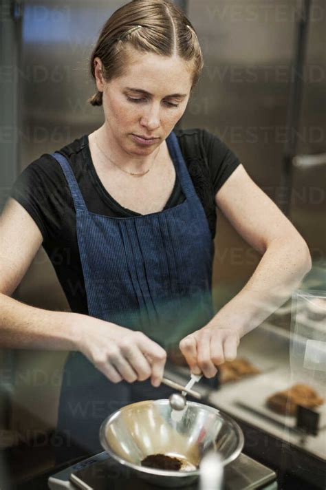 Woman Preparing Food In Commercial Kitchen Stock Photo